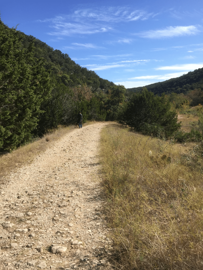 a trail in the hill country, where is laura traveling