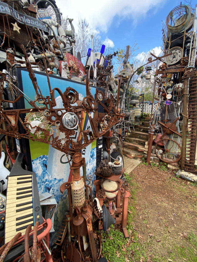 details of the cathedral of junk in austin, where is laura traveling